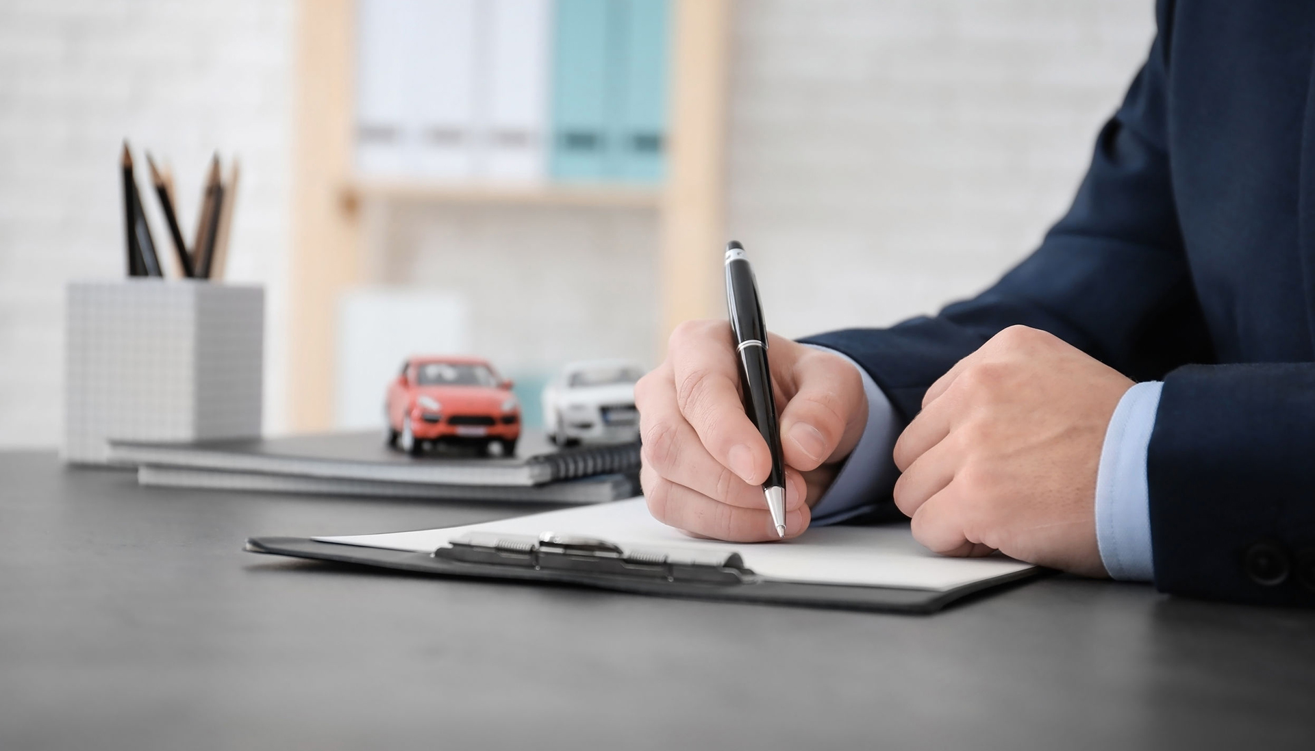 Man filling in car insurance form at table